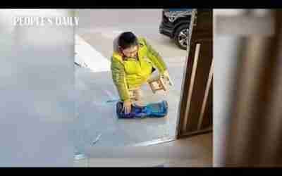 Boy without legs moves around on hoverboard in school